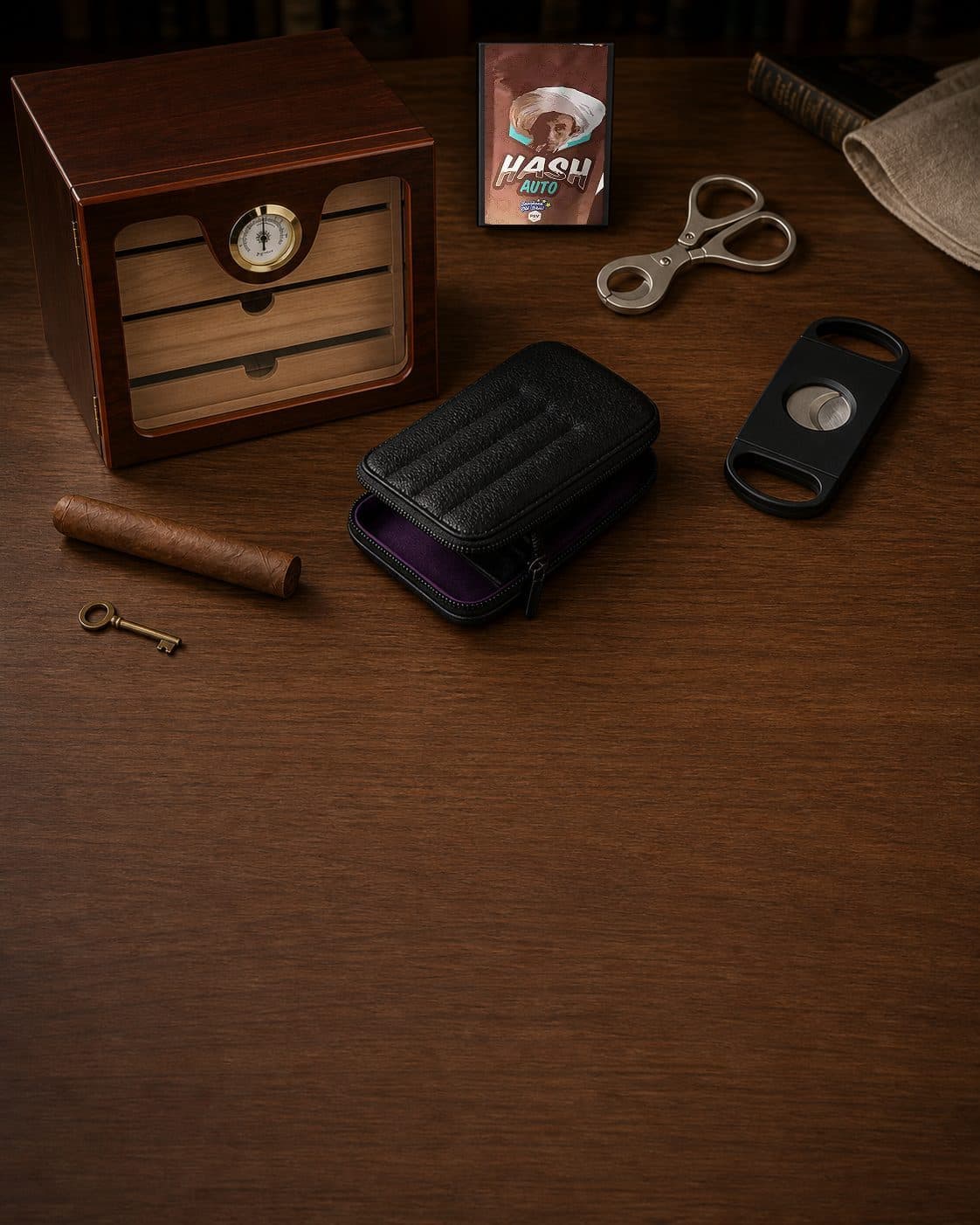 Humidor con higrómetro, estuche negro entreabierto, puro, llave, tijeras y cortapuros sobre una mesa de madera. Humidor con higrómetro, estuche negro entreabierto, puro, llave, tijeras y cortapuros sobre una mesa de madera.