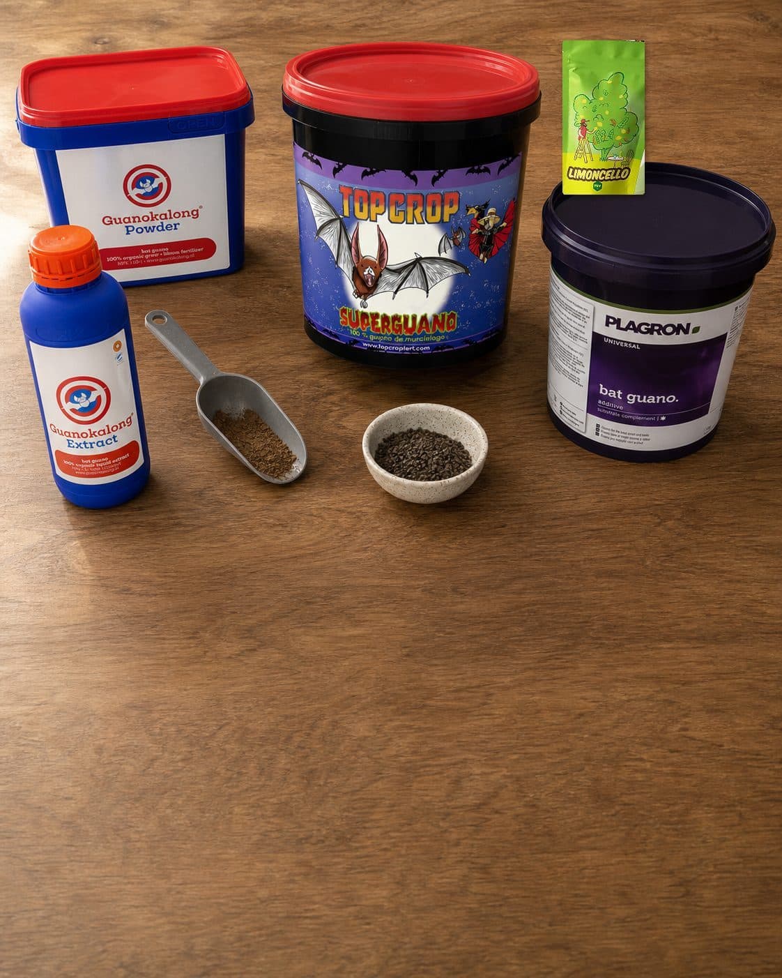 Envases de Guanokalong Powder y Extract, Top Crop Superguano y Plagron bat guano junto a una pala y un cuenco con gránulos. Envases de Guanokalong Powder y Extract, Top Crop Superguano y Plagron bat guano junto a una pala y un cuenco con gránulos.