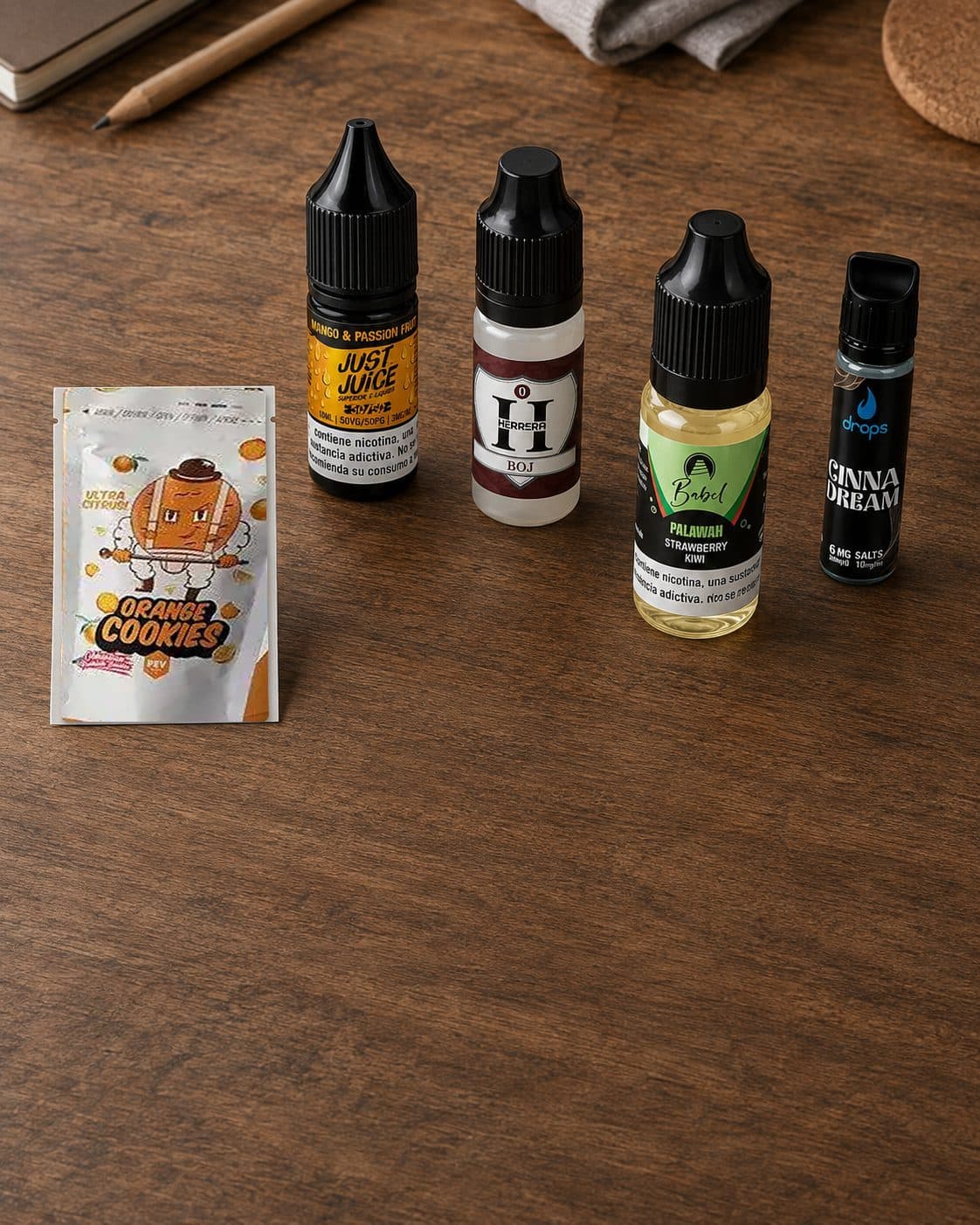 Selección de cuatro frascos de líquido para vapear de distintas marcas y formatos junto a un sobre Orange Cookies sobre madera. Selección de cuatro frascos de líquido para vapear de distintas marcas y formatos junto a un sobre Orange Cookies sobre madera.