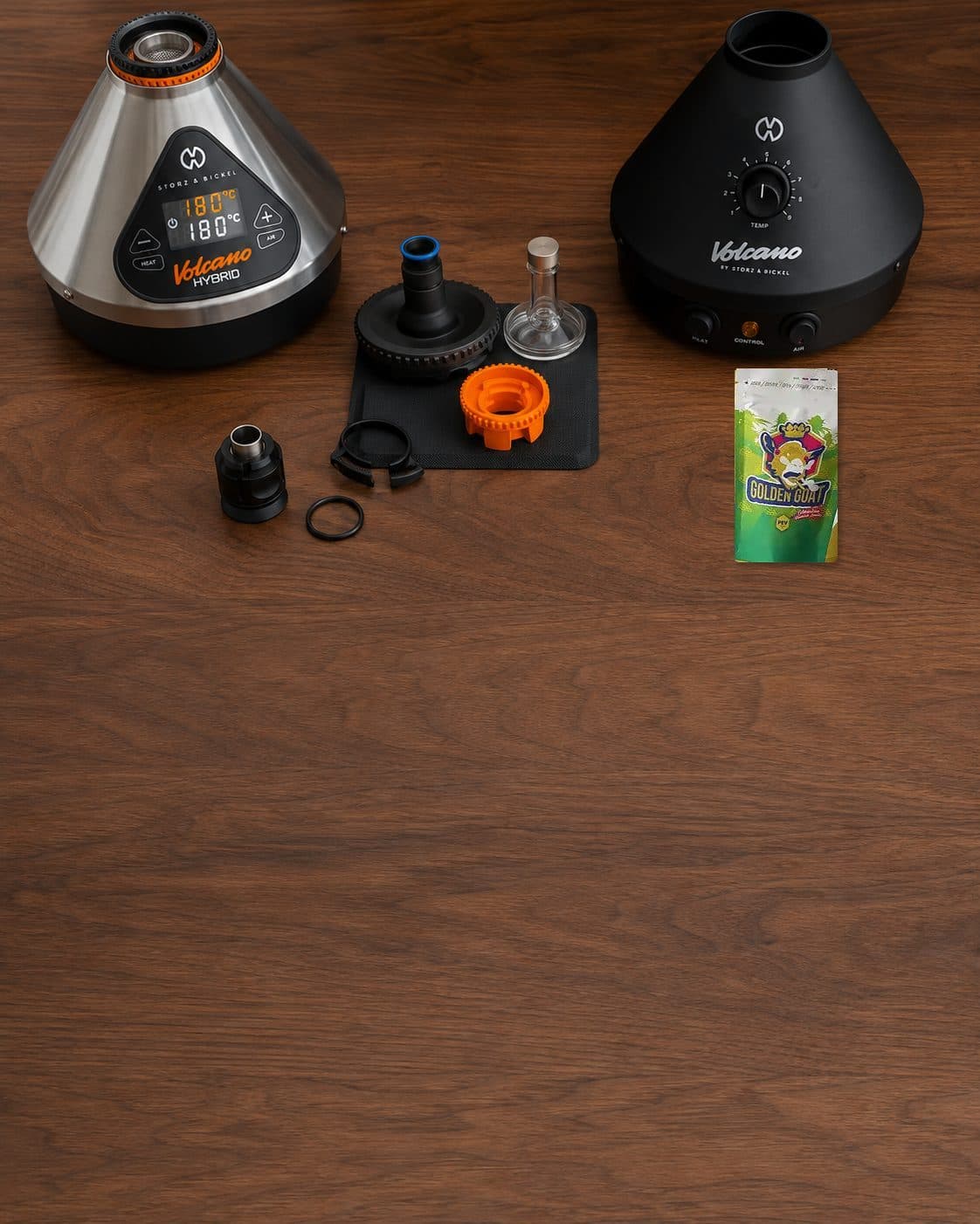 Vaporizadores Volcano con pantalla digital y dial, piezas desmontadas en el centro y un sobre de Golden Goat sobre una mesa. Vaporizadores Volcano con pantalla digital y dial, piezas desmontadas en el centro y un sobre de Golden Goat sobre una mesa.