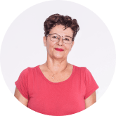 Retrato circular de una mujer con pelo corto, gafas y camiseta rosa, de frente sobre fondo claro.