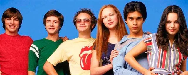 Los seis protagonistas de Aquellos maravillosos 70 posan ante un fondo azul, con camisetas de colores y una blusa de rayas.