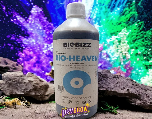 Botella de Bio·Heaven de BioBizz con tapón blanco y etiqueta clara, sobre una superficie con rocas y fondo de luces multicolores.
