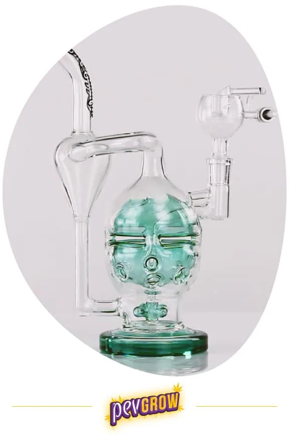 Bong transparente con cámara central de detalles verdes, tubos exteriores curvados, base circular y recipiente superior lateral. Bong transparente con cámara central de detalles verdes, tubos exteriores curvados, base circular y recipiente superior lateral.