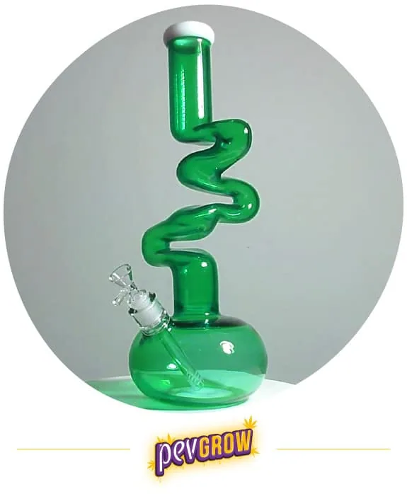 Bong verde con cuello largo en zigzag, borde blanco en la boquilla, depósito redondeado y cazoleta lateral transparente. Bong verde con cuello largo en zigzag, borde blanco en la boquilla, depósito redondeado y cazoleta lateral transparente.