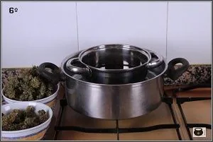Dos ollas metálicas encajadas sobre una cocina de gas, junto a dos recipientes con cogollos de cannabis. Dos ollas metálicas encajadas sobre una cocina de gas, junto a dos recipientes con cogollos de cannabis.