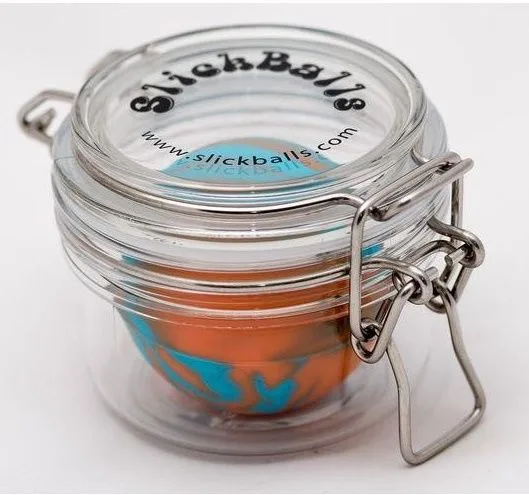 Tarro de vidrio con tapa y cierre metálico de palanca, rotulado «SlickBalls», con un recipiente naranja y azul en su interior.
