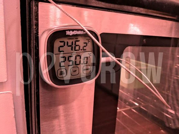 Termómetro digital fijado al frontal de un horno, con lecturas de 246,2 °F y 250,0 °F y un cable que cruza la puerta.