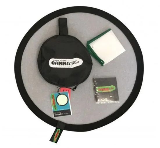 Tamiz circular de borde negro con una funda redonda, una pieza rectangular de marco verde y varios accesorios sobre la malla.