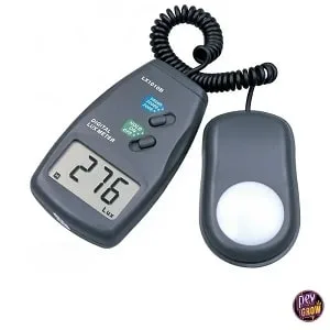 Luxómetro digital negro con lectura de 276 en pantalla y sensor separado con superficie circular blanca, conectado por cable en espiral. Luxómetro digital negro con lectura de 276 en pantalla y sensor separado con superficie circular blanca, conectado por cable en espiral.
