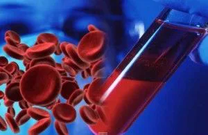 Montaje de glóbulos rojos junto a un tubo inclinado con sangre, sostenido por una mano con guante azul. Montaje de glóbulos rojos junto a un tubo inclinado con sangre, sostenido por una mano con guante azul.