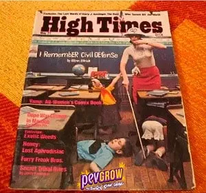 Revista High Times sobre una superficie naranja, con una portada que muestra una escena de aula y el texto «Remember Civil Defense». Revista High Times sobre una superficie naranja, con una portada que muestra una escena de aula y el texto «Remember Civil Defense».