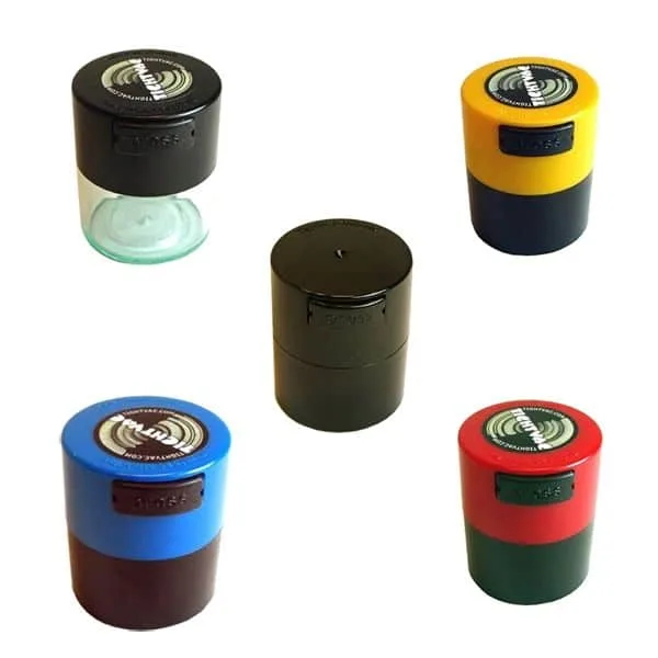Cinco recipientes cilíndricos pequeños con tapas negras, amarilla, azul y roja; uno tiene la base transparente.