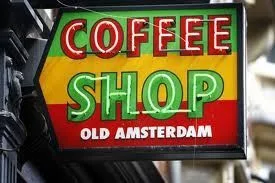 Rótulo de un local con el texto «COFFEE SHOP OLD AMSTERDAM» sobre franjas verdes, amarillas y rojas. Rótulo de un local con el texto «COFFEE SHOP OLD AMSTERDAM» sobre franjas verdes, amarillas y rojas.