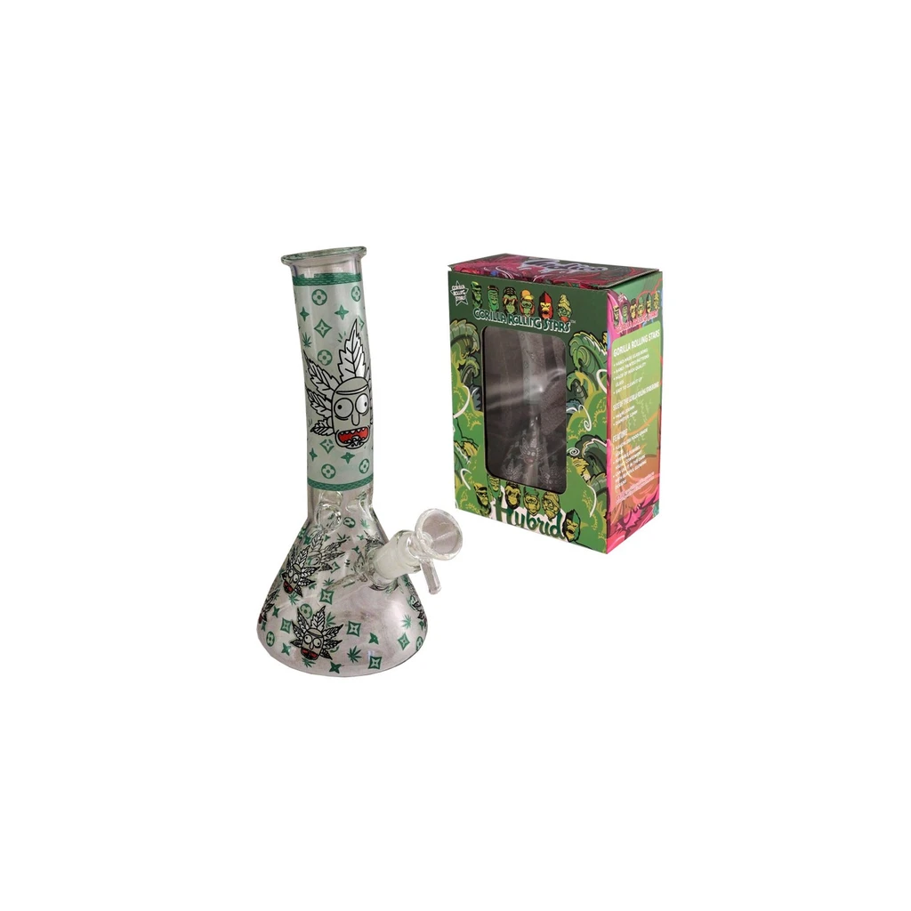 Bong de cristal transparente con base ancha, cuello recto y dibujos verdes de hojas y personajes, junto a una caja decorada con ventana.