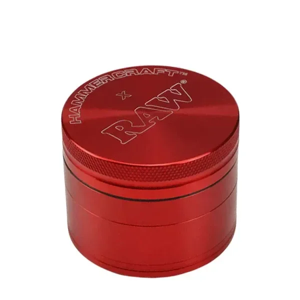 Grinder cilíndrico rojo RAW, con varios compartimentos, borde estriado y logotipos RAW y HAMMERCRAFT grabados en la tapa.