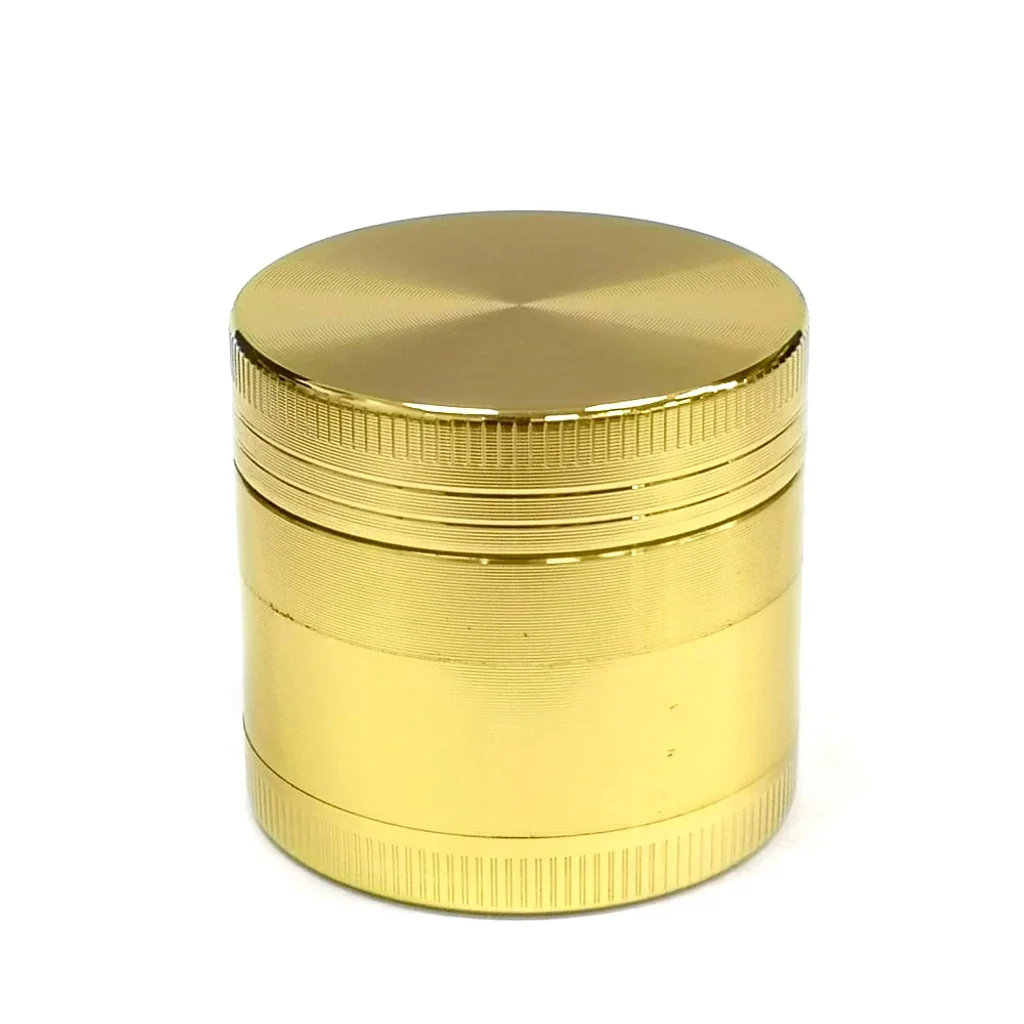 Grinder Metal Gold cerrado, de forma cilíndrica y acabado dorado, con tapa lisa y bordes estriados sobre fondo blanco.