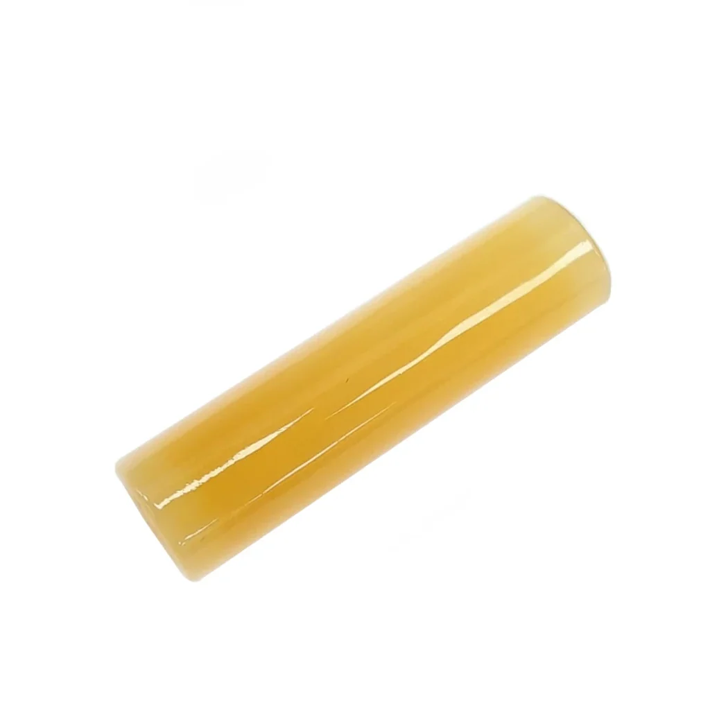 Filtro Cristal 7 Hole Yellow Jade de forma cilíndrica, amarillo y brillante, colocado en diagonal sobre fondo blanco.