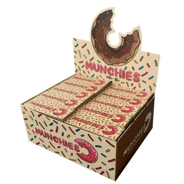 Expositor de filtros Monkey King Munchies Unbleached con varias cajas beige, letras rosas y dibujos de rosquillas y virutas de colores.