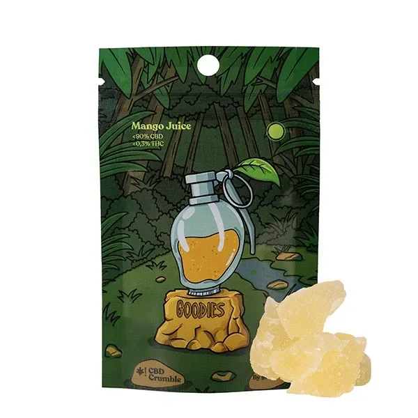 Bolsa de CBD Goodies Crumble Mango Juice con ilustración de selva y granada, junto a fragmentos amarillos sobre fondo blanco.