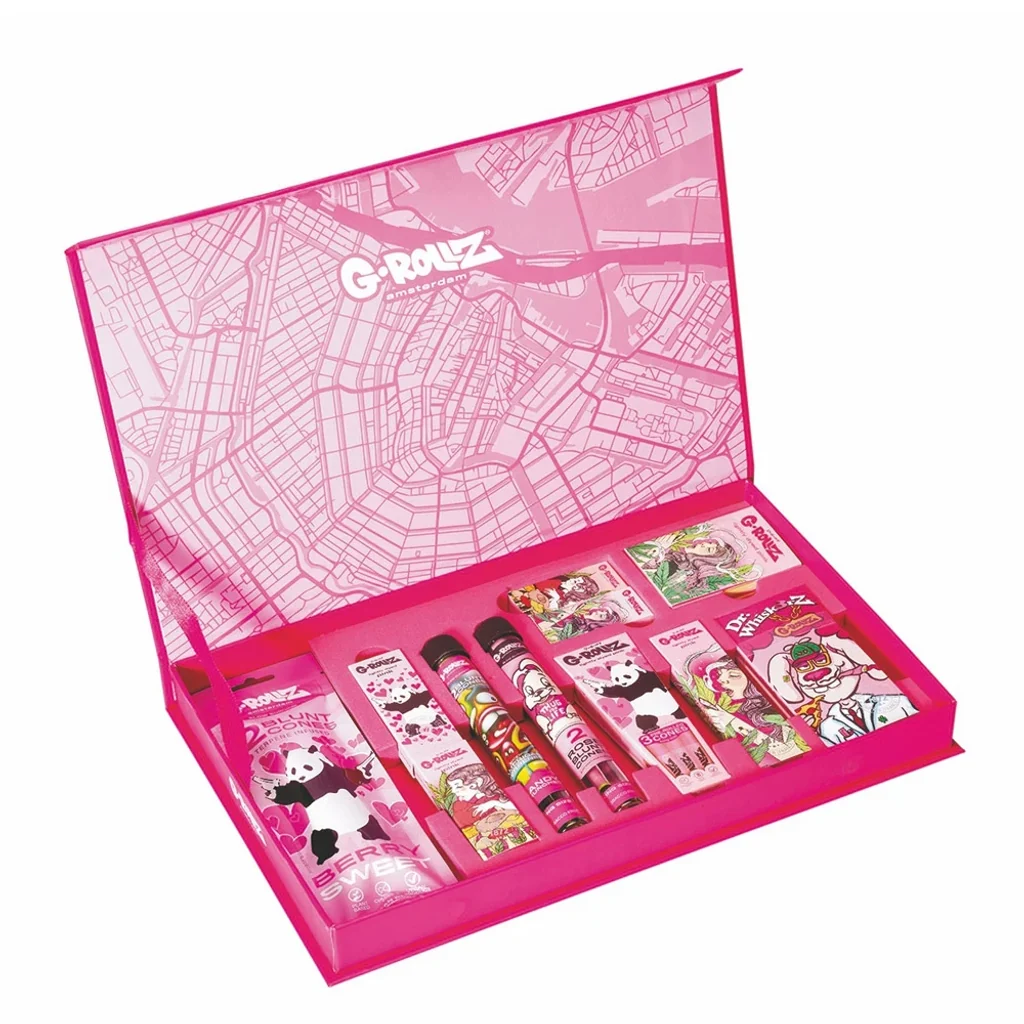 Caja regalo G-Rollz abierta, de color rosa, con un mapa en el interior de la tapa y varios paquetes y tubos con ilustraciones.