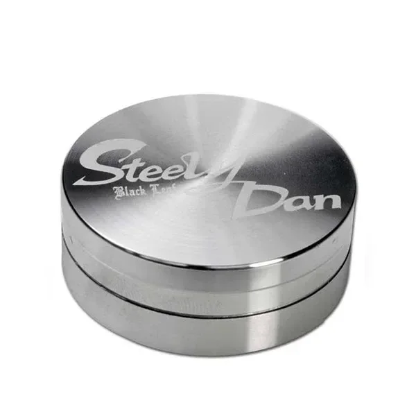 Grinder Steely Dan cerrado, de forma circular y acabado plateado, con el nombre grabado en la tapa sobre fondo blanco.