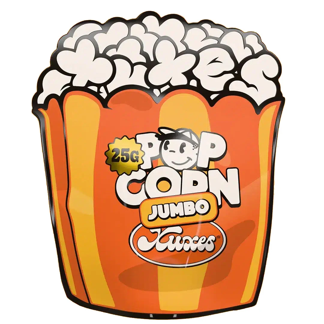 Envase Xuxes Pop Corn Jumbo de 25 g con forma de recipiente de palomitas, franjas naranjas y amarillas y dibujos blancos en la parte superior.