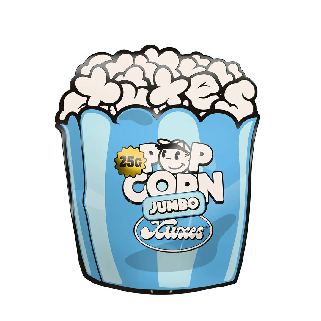 Envase azul de Xuxes Pop Corn Jumbo con forma de cubo de palomitas, dibujos blancos en la parte superior y distintivo de 25 g.