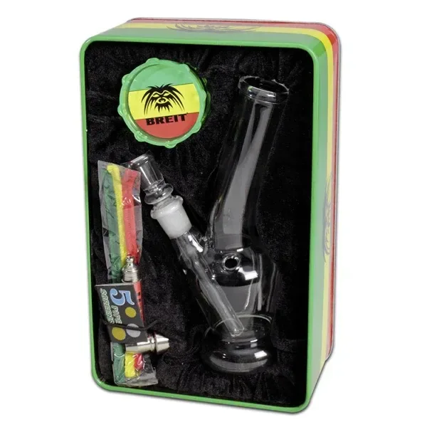 Set en caja con borde verde e interior negro: bong transparente de cuello curvado, grinder Breit y accesorios de limpieza.