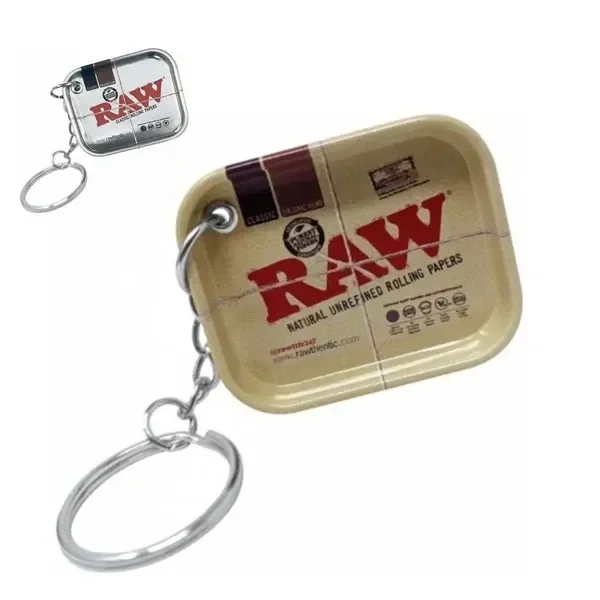 Dos modelos de llavero con minibandeja RAW, uno beige en primer plano y otro plateado arriba a la izquierda, ambos con anilla y cadena.