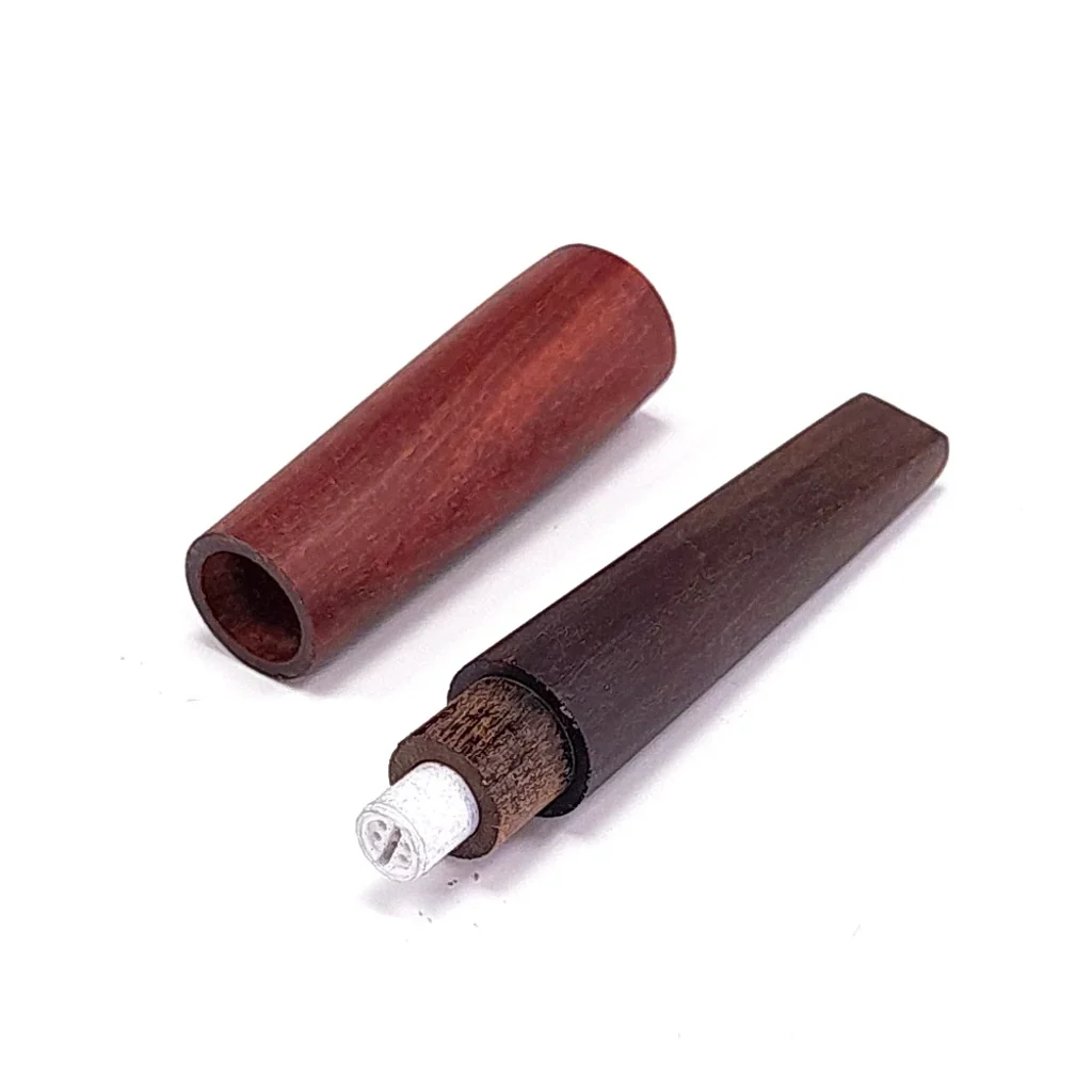 Pipa de madera desmontada en dos piezas, con una cubierta rojiza y un cuerpo oscuro que deja visible un filtro blanco.