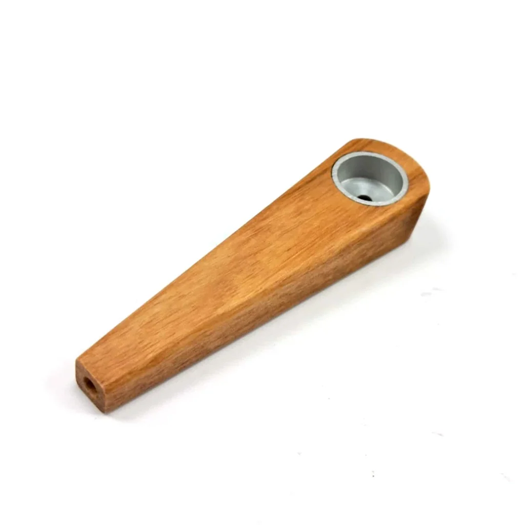 Pipa de madera alargada y de perfil rectangular, con cazoleta metálica circular y abertura en el extremo estrecho, sobre fondo blanco.
