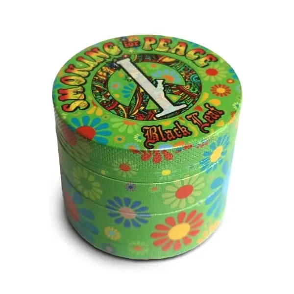 Grinder cilíndrico verde Smoking for Peace, decorado con flores multicolores y un símbolo de la paz en la tapa.
