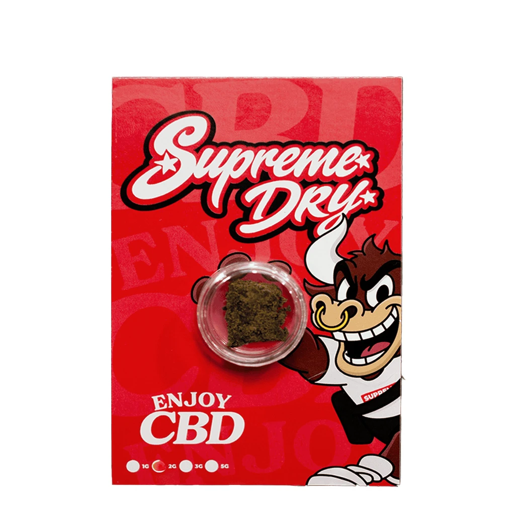 Envase rojo de Supreme Dry Enjoy CBD con un toro de dibujos y una cápsula transparente que muestra un fragmento marrón.