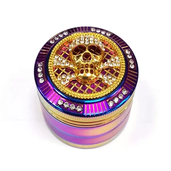 Grinder Rainbow cerrado con acabado multicolor, calavera dorada en relieve y adornos brillantes en la tapa, sobre fondo blanco.