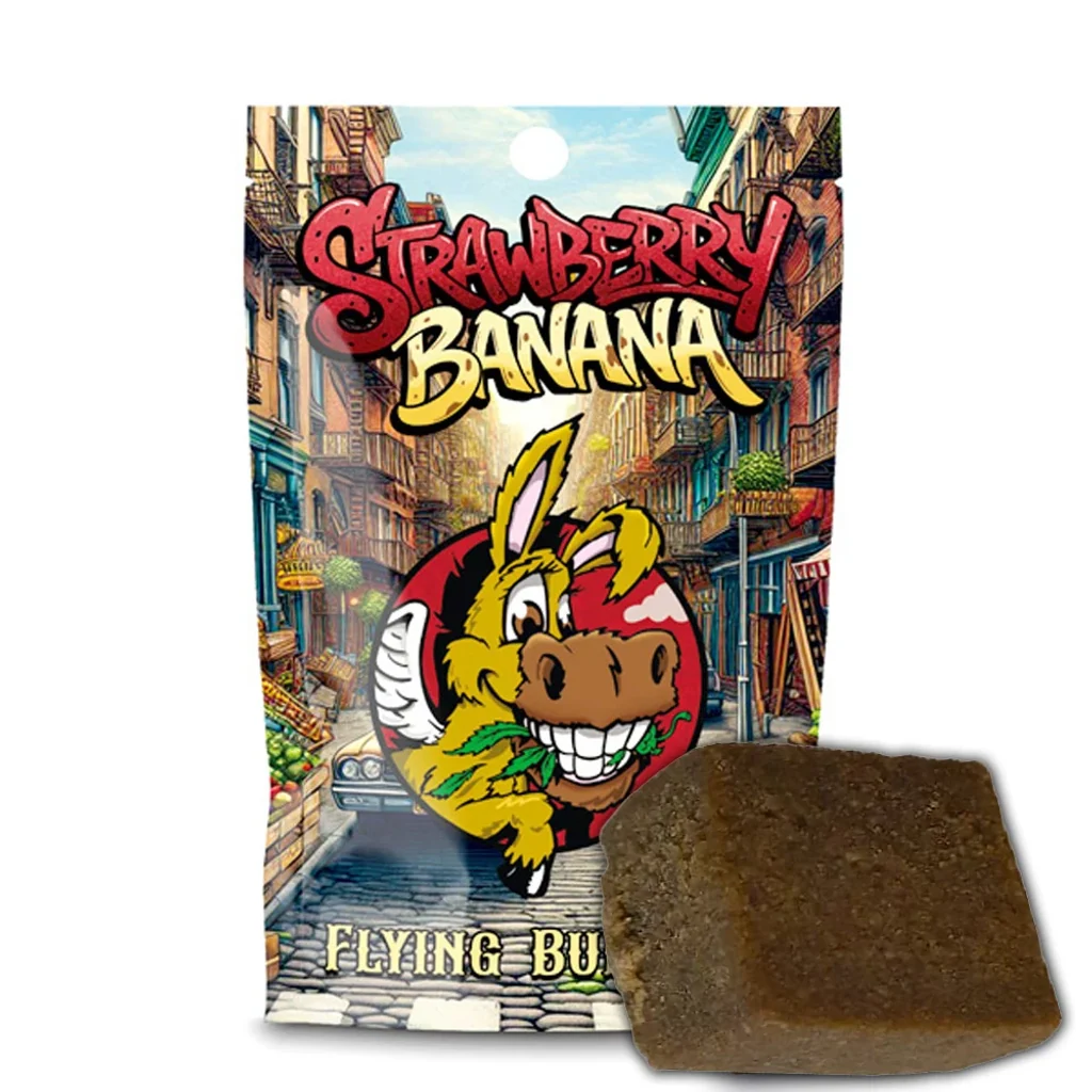 Bloque marrón de CBD Hash Flying Burrito Strawberry Banana ante un envase ilustrado con un burro y una calle urbana.