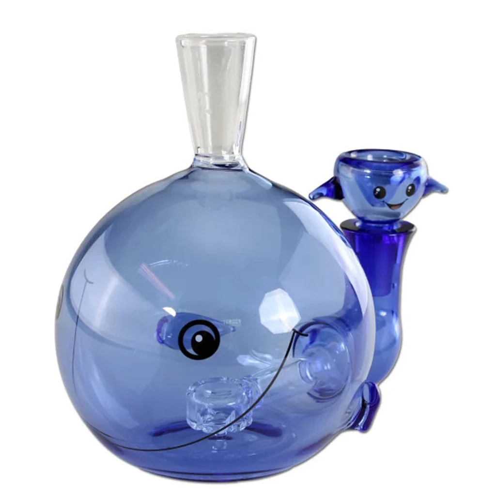 Bong de cristal Moby Dick azul con cuerpo redondeado de ballena, boca transparente y cazoleta lateral con cara sonriente.