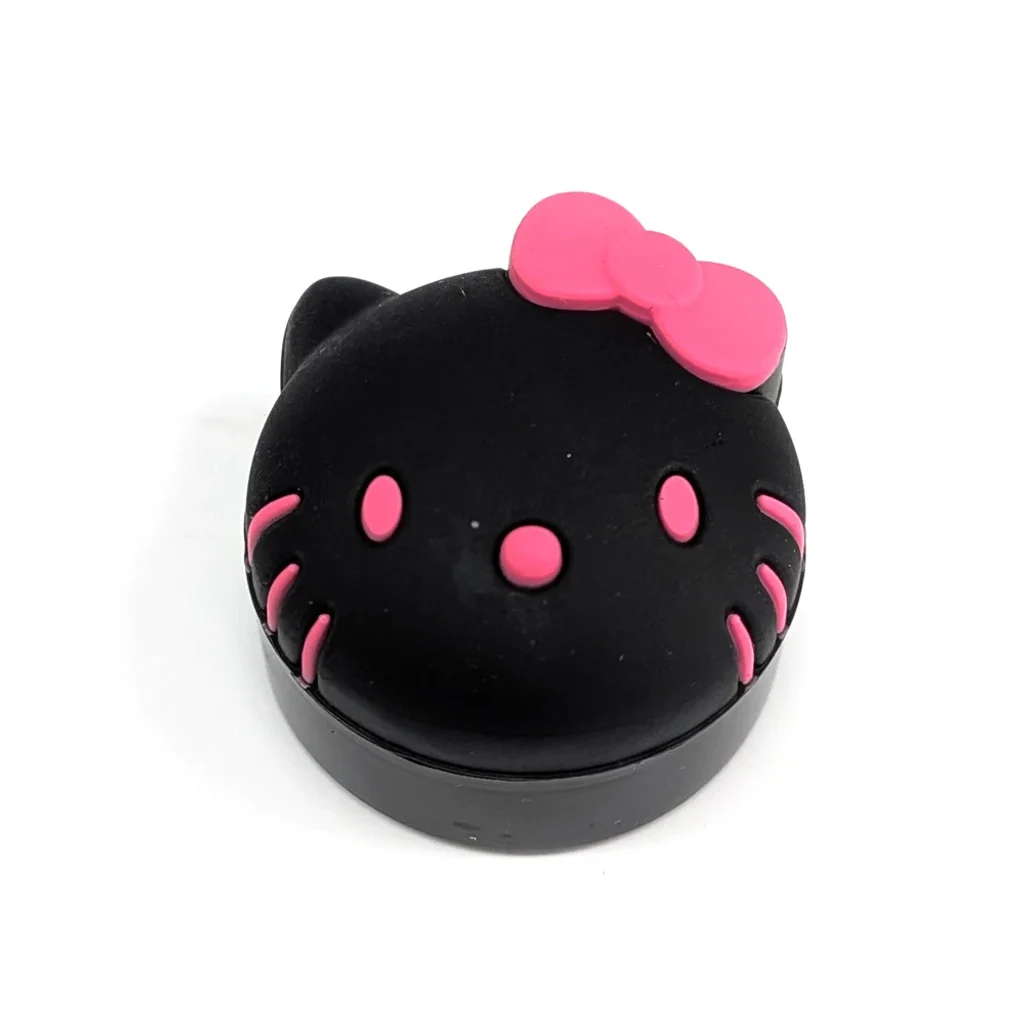 Bote negro con tapa en forma de cara de Hello Kitty, con lazo, ojos, nariz y bigotes rosas, sobre fondo blanco.