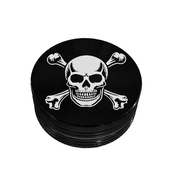 Grinder negro redondo con una calavera y huesos cruzados blancos en la tapa y bordes estriados, sobre fondo blanco.