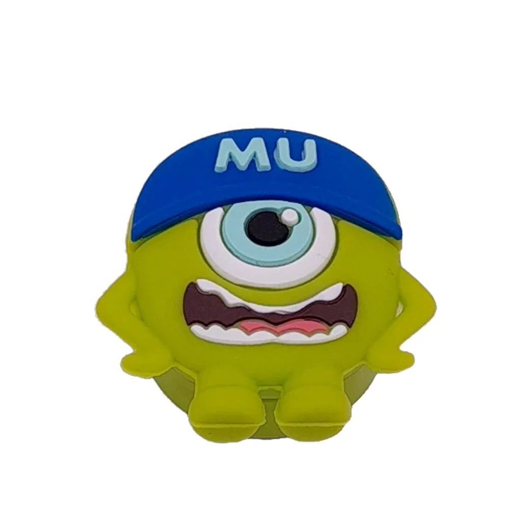 Bote de silicona MU con forma de personaje verde de un solo ojo, boca abierta y gorra azul con las letras MU.