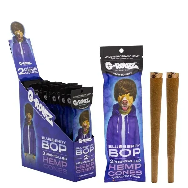 Expositor y sobres morados G-Rollz Blueberry Bop con un perro ilustrado, junto a conos de cáñamo marrones con boquilla.