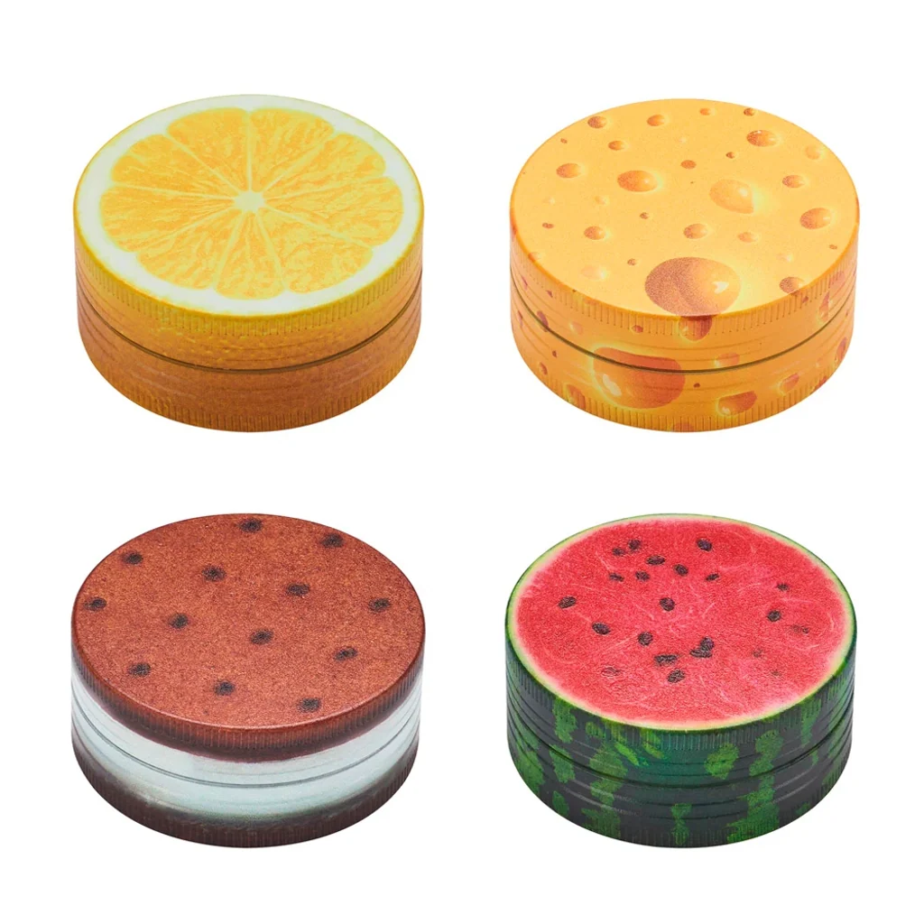 Selección de grinders redondos CHAMP con diseños de rodaja de naranja, queso, galleta y sandía sobre fondo blanco.