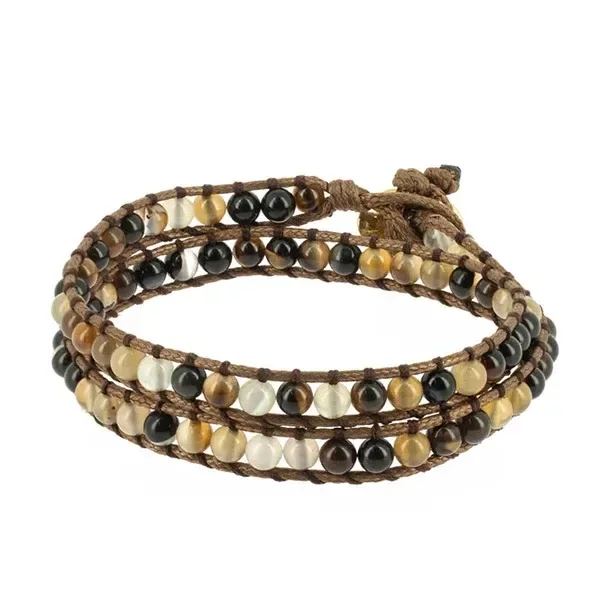 Pulsera Naga de varias vueltas con cordones marrones y cuentas redondas en tonos negros, crema, ocres y marrones sobre fondo blanco. Pulsera Naga de varias vueltas con cordones marrones y cuentas redondas en tonos negros, crema, ocres y marrones sobre fondo blanco.