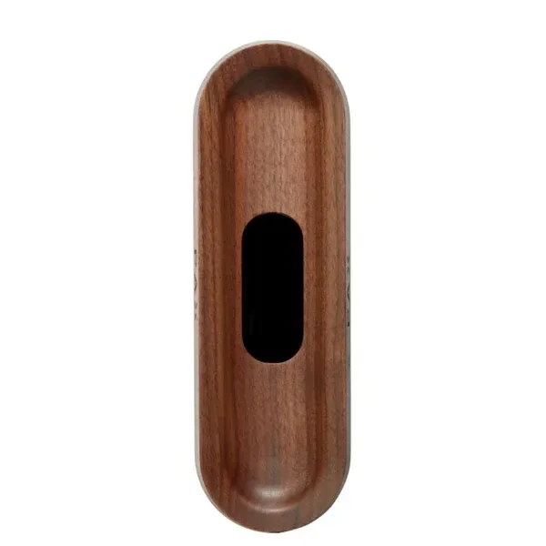 Pieza alargada de aspecto de madera, con extremos redondeados, superficie interior rebajada y abertura central negra, vista desde arriba.