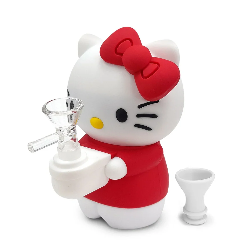 Bong con forma de Hello Kitty, blanco y rojo, con lazo grande, cazoleta transparente frontal y una pieza blanca separada al lado.