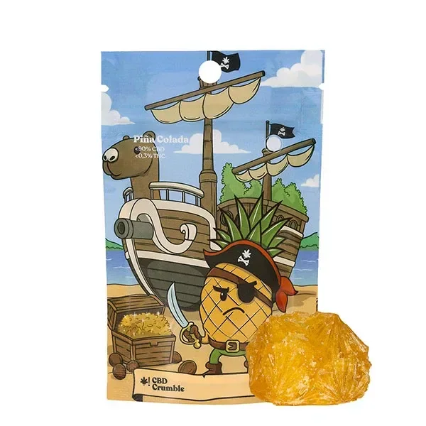 Bolsa de CBD Goodies Crumble Piña Colada con una piña pirata y un barco ilustrados, junto a un fragmento amarillo anaranjado.