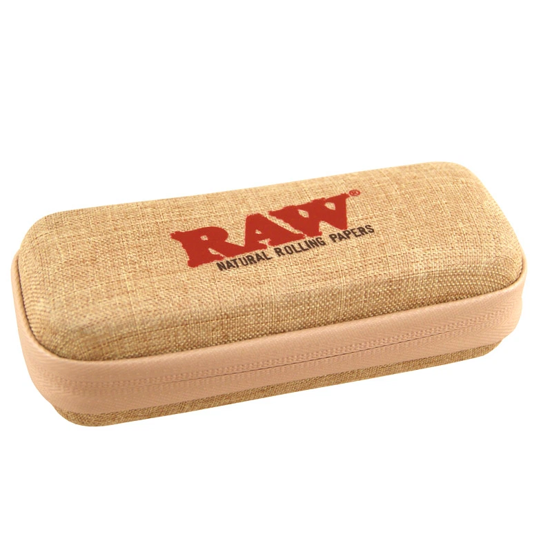 Funda RAW Cone cerrada, de forma rectangular con esquinas redondeadas, tejido beige, cremallera y logotipo rojo en la tapa.
