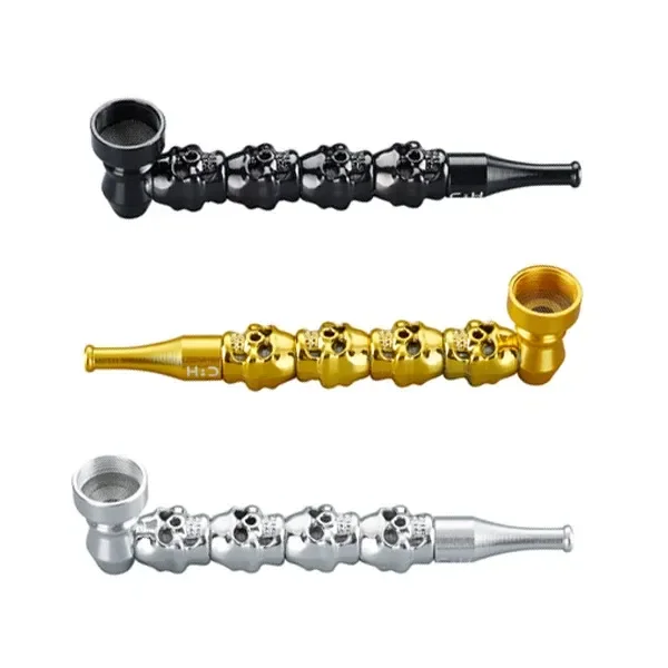 Pipas Metal Skulls CHAMP con relieves de calaveras, cazoleta lateral y boquilla alargada, en acabados negro, dorado y plateado.