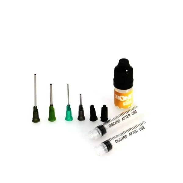 Kit de recarga Honey Stick Oil con dos jeringas transparentes, cuatro puntas metálicas de bases coloreadas, dos piezas negras y un pequeño frasco.