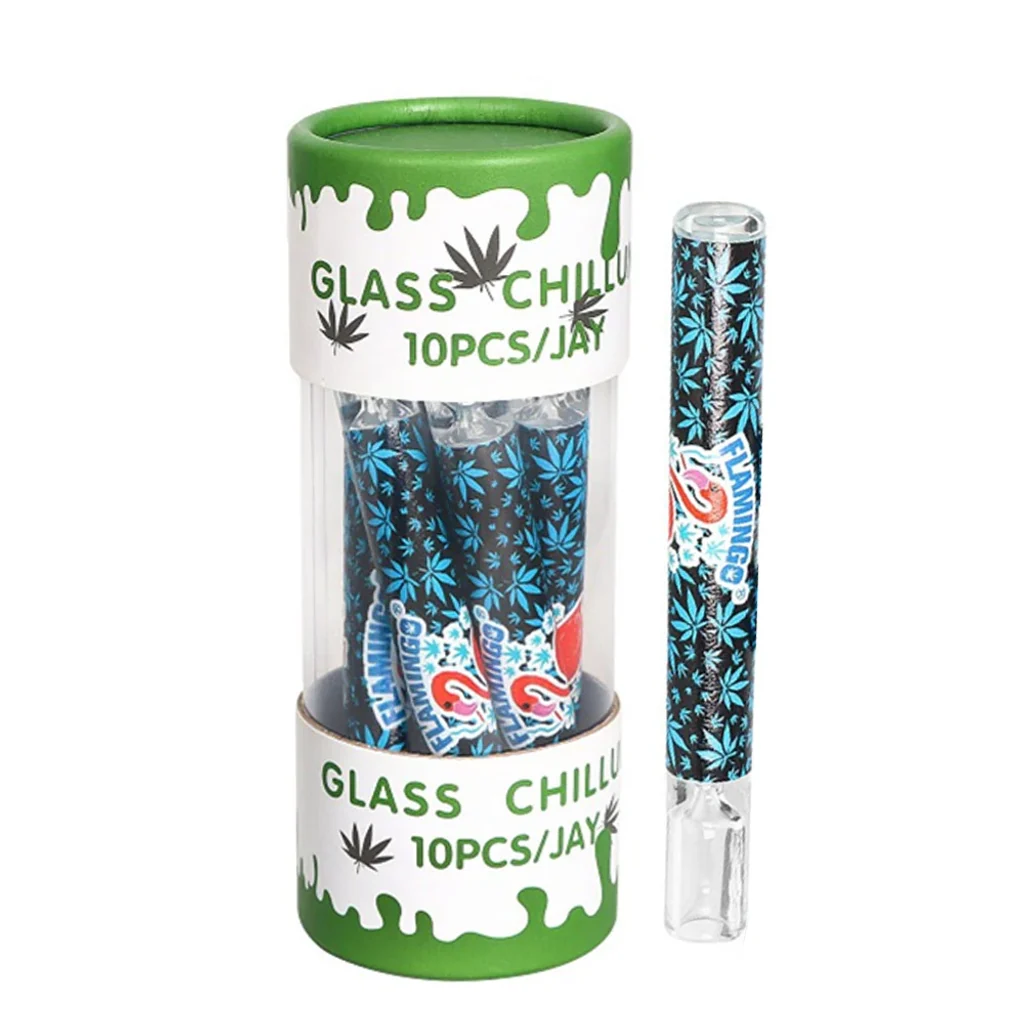 Pipa de cristal alargada con hojas azules y dibujo multicolor, junto a un recipiente cilíndrico verde y transparente con varias pipas.